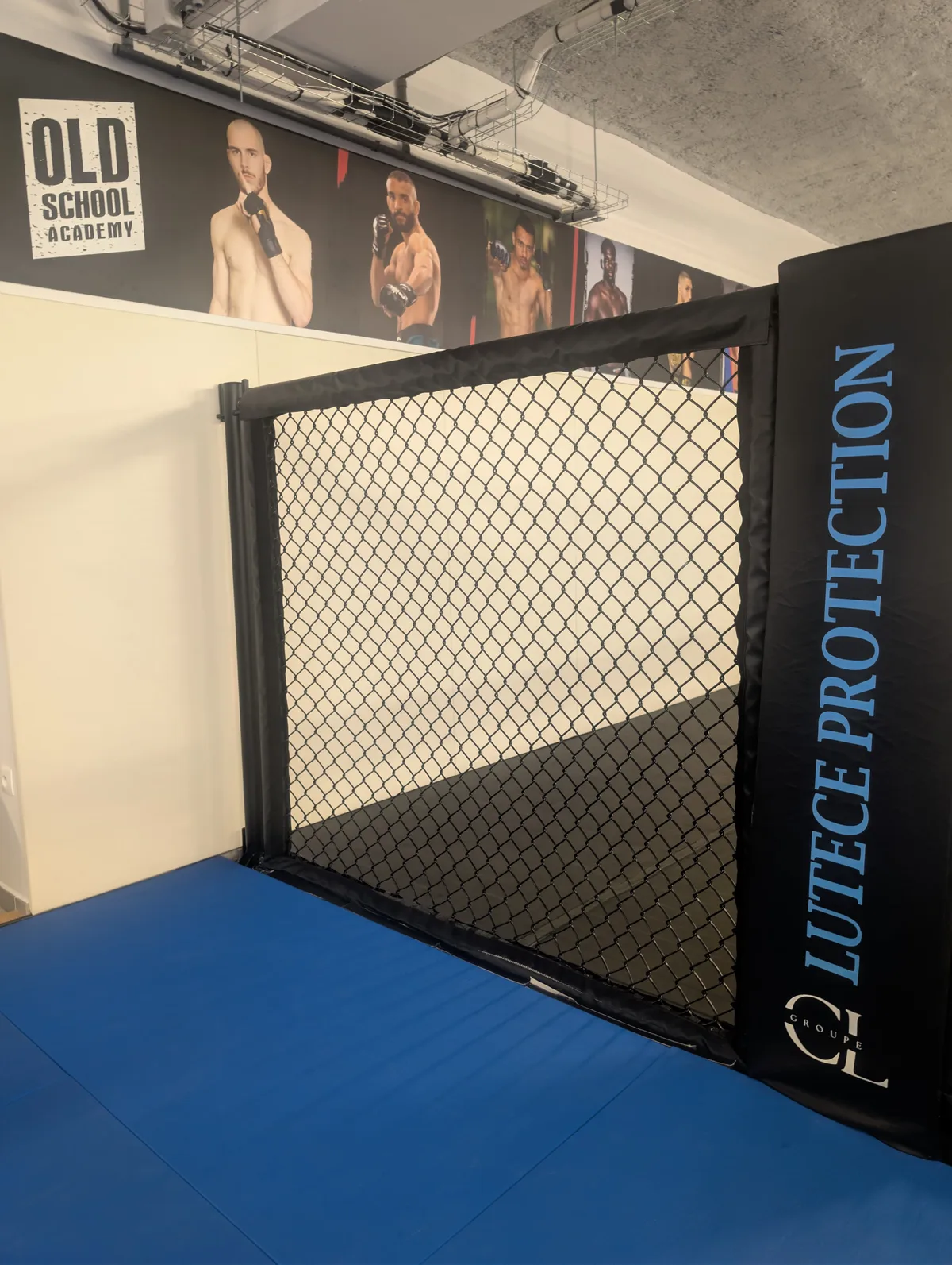 Intérieur de la cage MMA avec tapis de combat et photos de combattants